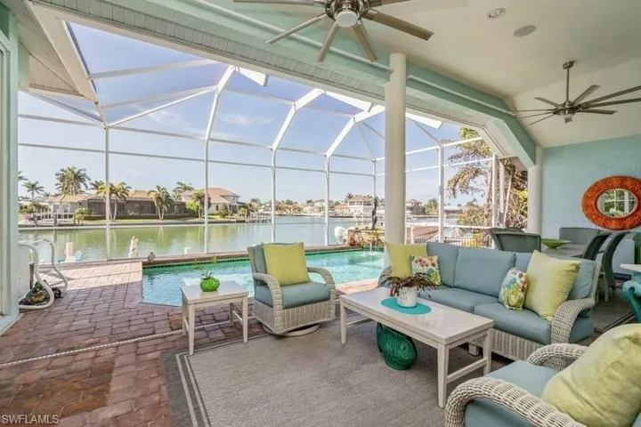 View of patio / terrace with an outdoor living space, glass enclosure, and a water view