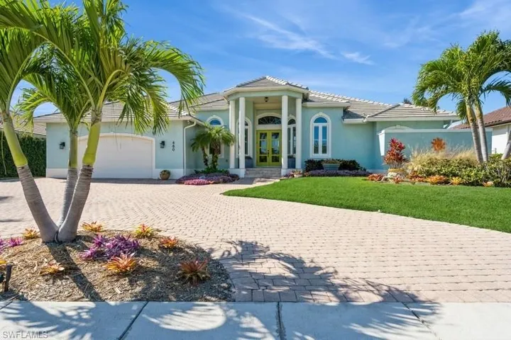 Mediterranean / spanish-style home with a garage, a front lawn, and french doors