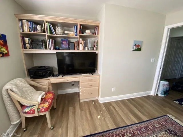 Office space featuring built in study area and wood finished floors