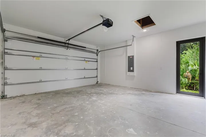 Garage with electric panel and a garage door opener