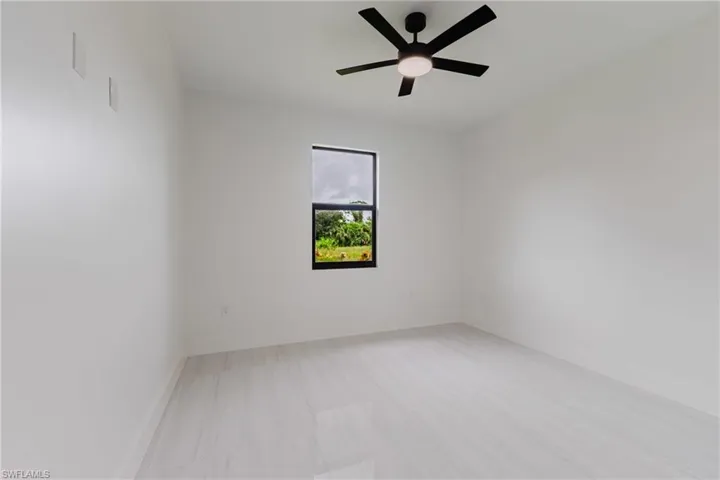 Empty room with a ceiling fan and light wood-type flooring