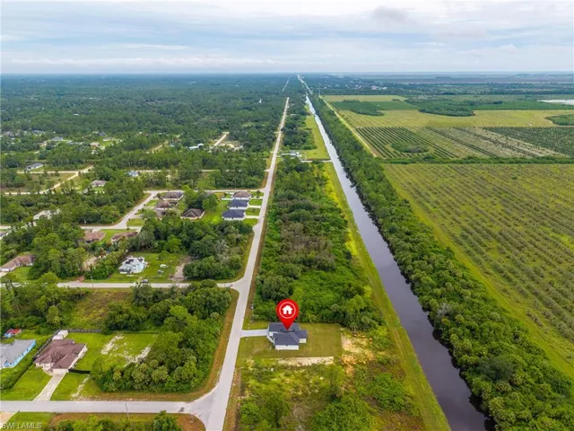 View of rural area with a nearby body of water and rows of crops