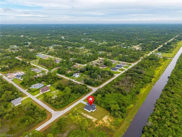 Aerial view of property and surrounding area featuring a nearby body of water
