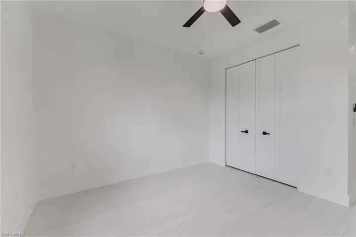 Unfurnished bedroom featuring a ceiling fan, a closet, and light tile patterned floors