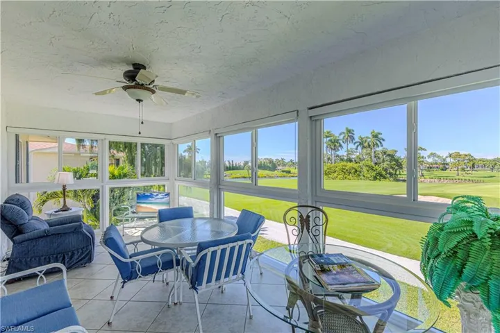 Sunroom / solarium featuring ceiling fan, tile patterned floors, golf course view, and outdoor dining space