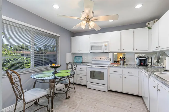Kitchen featuring white appliances, white cabinetry, light countertops, recessed lighting, and ceiling fan