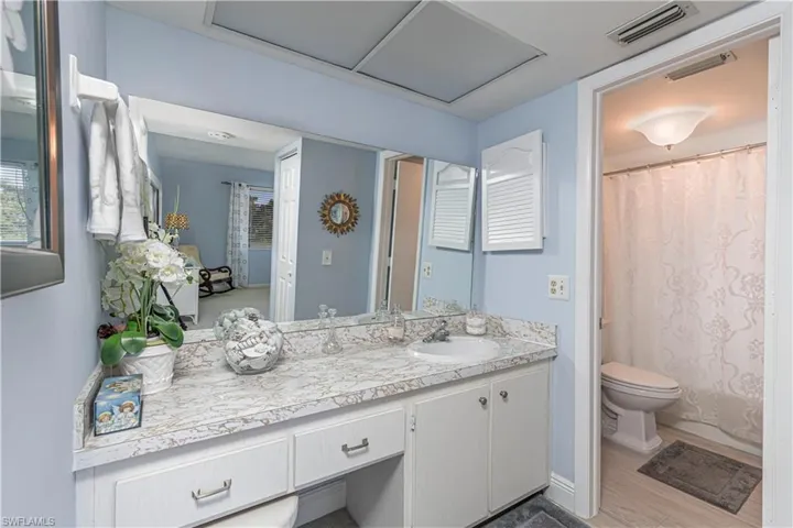 Bathroom with curtained shower, vanity, and light wood finished floors