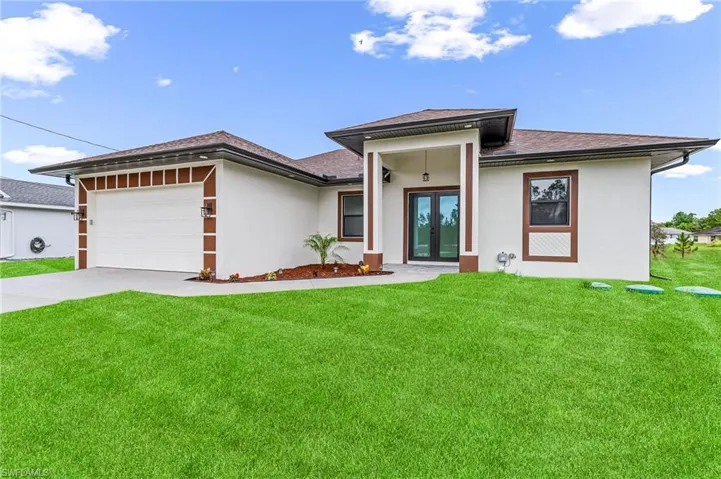 View of front of house with a garage and a front lawn