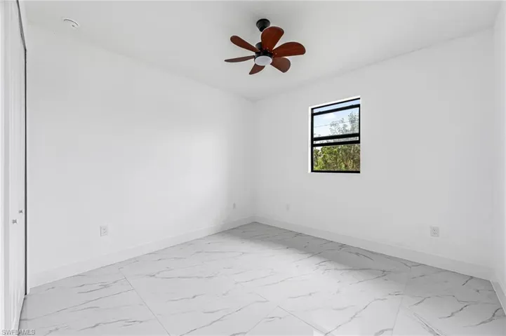 Spare room with ceiling fan and tile flooring