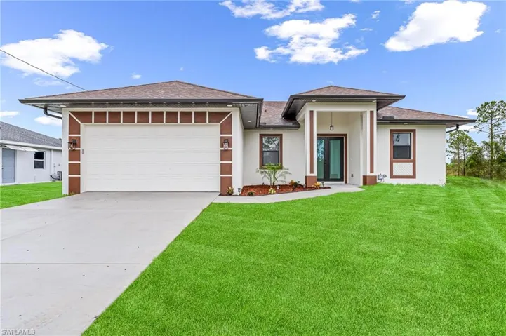 Prairie-style home with a front lawn and a garage