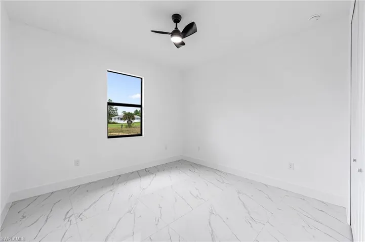 Tiled spare room with ceiling fan