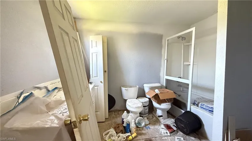 Bathroom featuring toilet and a textured wall