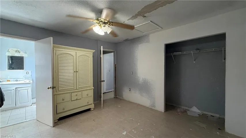 Unfurnished bedroom featuring a textured ceiling, a ceiling fan, and a closet