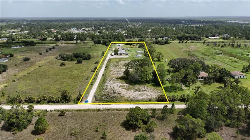 Aerial view of sparsely populated area featuring property boundaries highlighted and a pastoral area