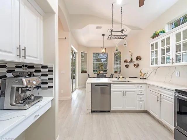 Kitchen featuring white cabinetry, light wood-finish flooring, and light countertops with veining