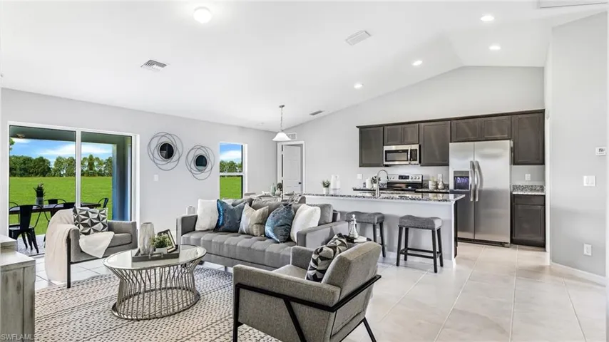 Living room featuring lofted ceiling and light tile floors