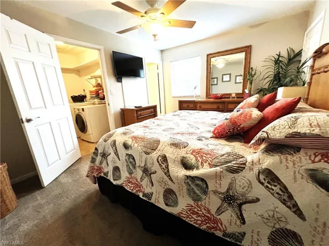 Carpeted bedroom with washer / clothes dryer and ceiling fan