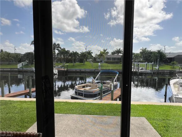 View of dock featuring a lawn and a water view
