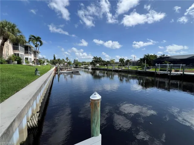 Dock area with a lawn and a water view