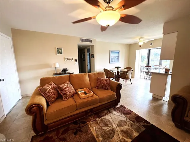 Living room featuring a textured ceiling and ceiling fan