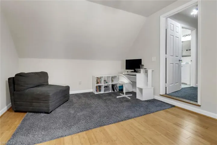 Living area featuring hardwood / wood-style flooring and lofted ceiling