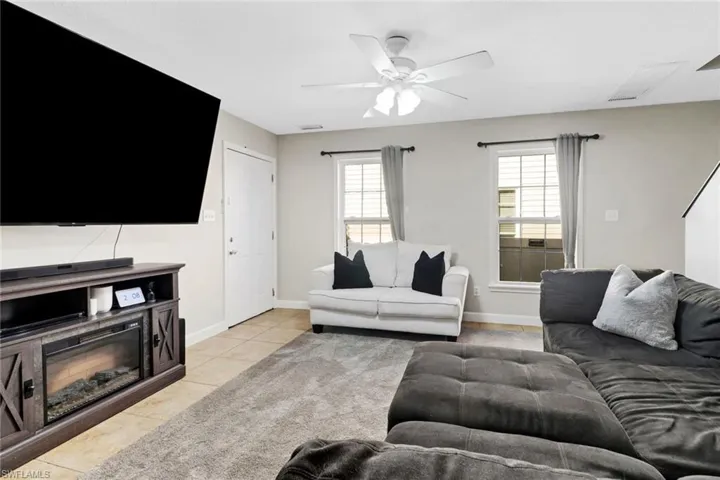 Living room featuring ceiling fan and light tile patterned floors
