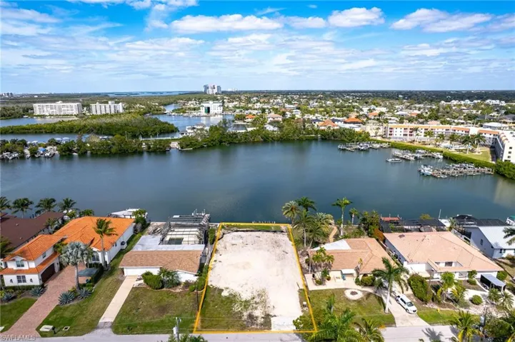 Aerial overview of property's location featuring a nearby body of water, property boundaries highlighted, and a marina