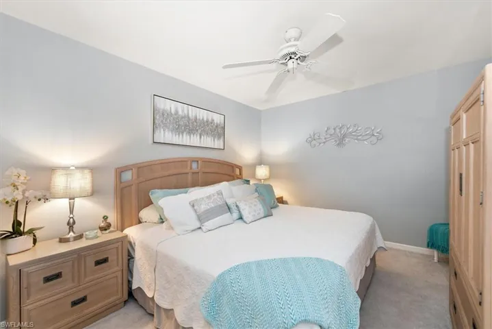 Bedroom with light carpet and a ceiling fan
