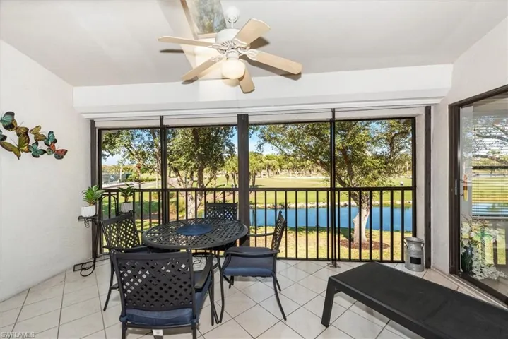 Sunroom / solarium with a water view, plenty of natural light, and tile patterned flooring