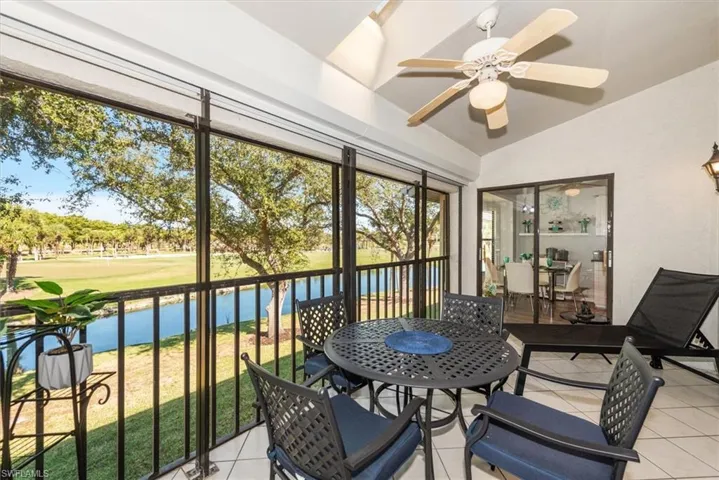 Sunroom / solarium with a water view, lofted ceiling, ceiling fan, and outdoor dining space