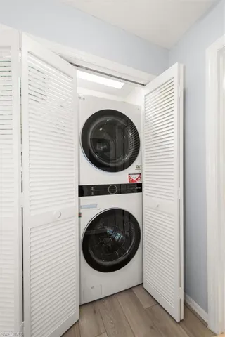 Washroom featuring estacked washer and dryer and wood finished floors
