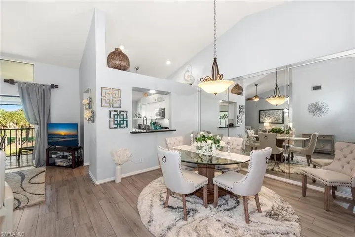 Dining space featuring light wood-type flooring and high vaulted ceiling