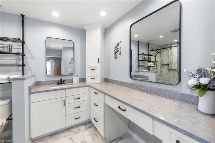 Bathroom with light marble finish flooring, a marble finish shower, vanity, and recessed lighting