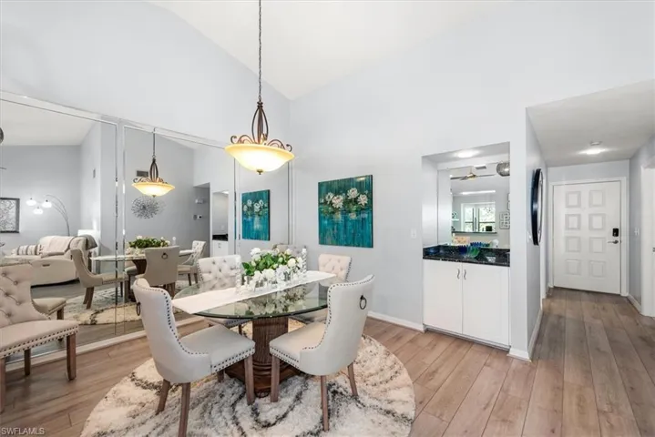 Dining area featuring light wood-style floors and high vaulted ceiling