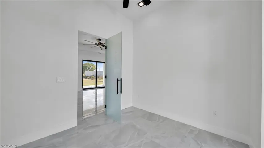 Spare room featuring light marble finish flooring and a ceiling fan