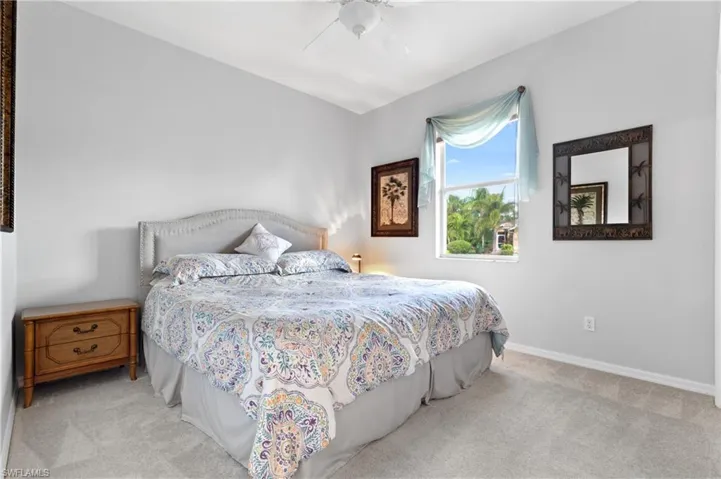 Carpeted bedroom featuring ceiling fan