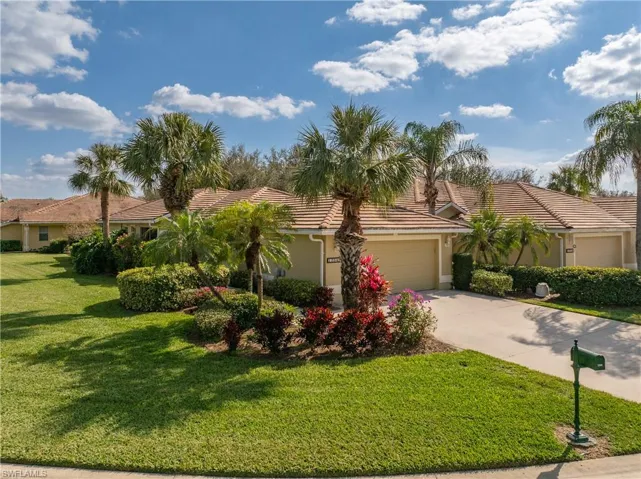 View of front of property featuring a garage and a front lawn