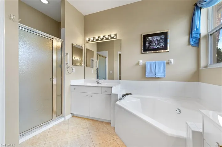 Bathroom featuring tile patterned floors, independent shower and bath, and vanity