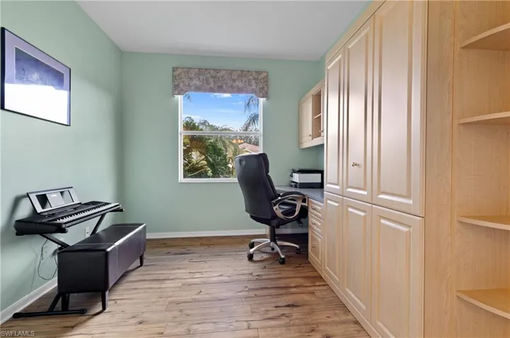 Office featuring built in desk and light hardwood / wood-style flooring