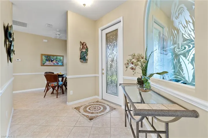 Foyer with ceiling fan and light tile patterned floors