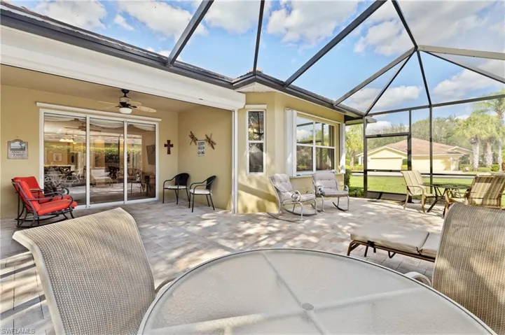 View of patio featuring ceiling fan and glass enclosure