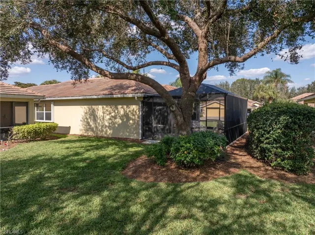 Rear view of house featuring a lanai and a lawn