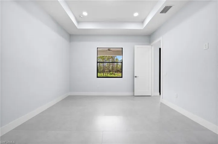 Spare room with a tray ceiling and recessed lighting