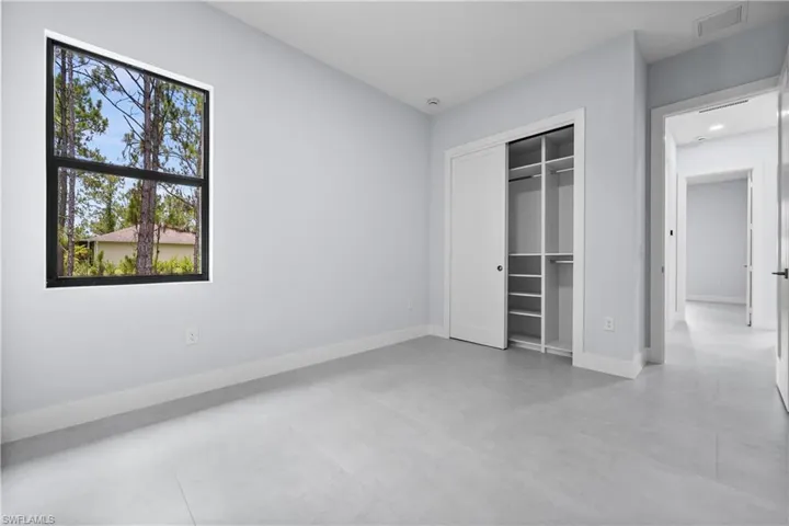 Unfurnished bedroom featuring finished concrete floors and a closet
