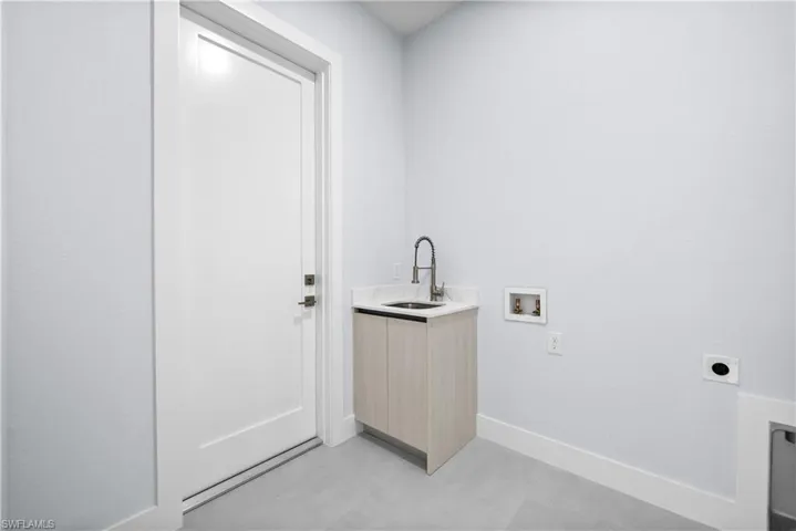 Laundry area with hookup for a washing machine, electric dryer hookup, and cabinet space