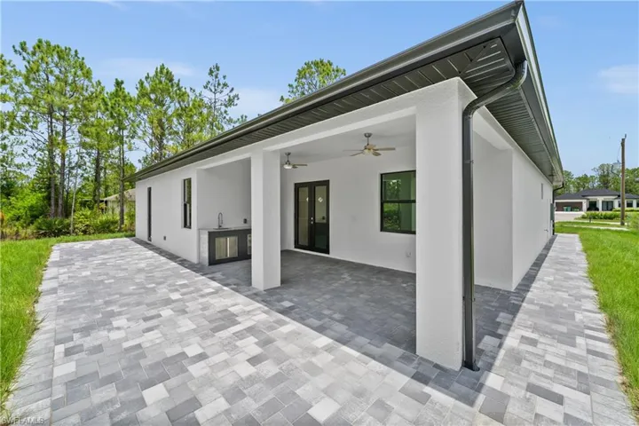 View of patio featuring ceiling fan, an outdoor kitchen, and french doors