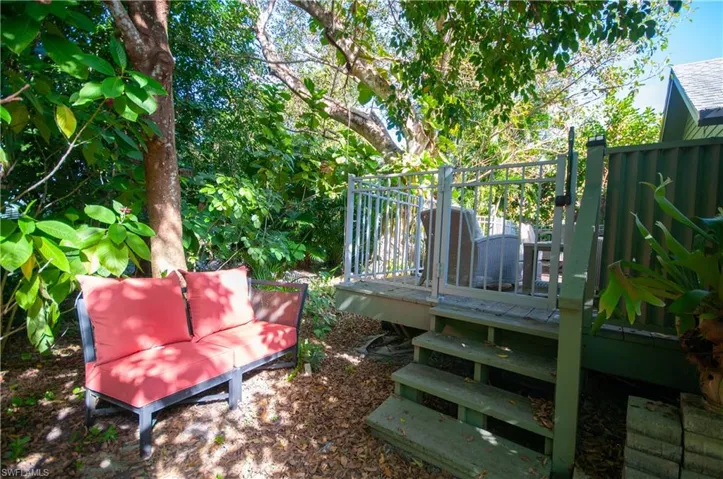 View of back yard with a deck, steps to lush trees and paths