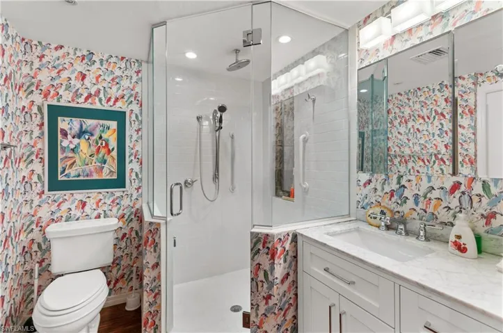 Full bathroom featuring wallpapered walls, birds . vanity, and a shower stall