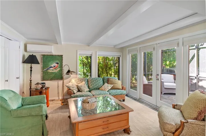 Sunroom / solarium with french doors, beam ceiling, and a wall mounted AC