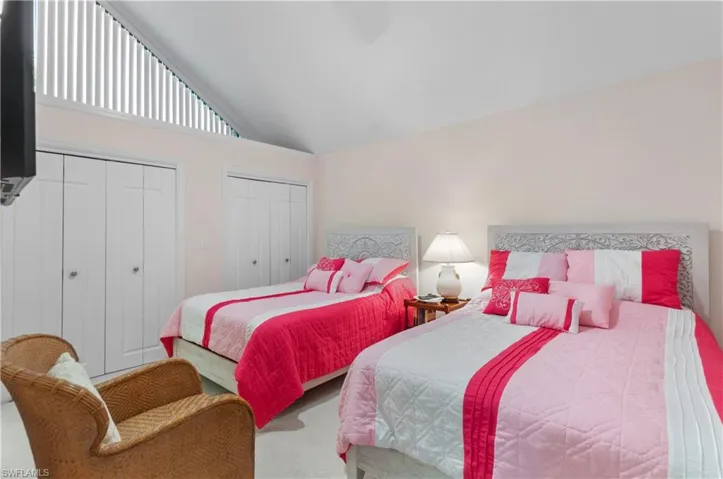 Bedroom featuring two closets, high vaulted , ceiling, and carpet floors two beds main on 2st floor